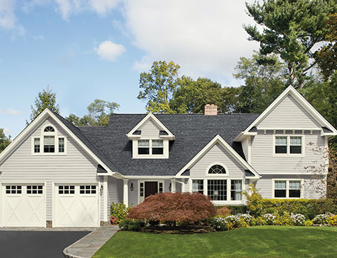 A light gray coloured house with vinyl siding and two door garage. A light gray coloured house with vinyl siding and two door garage.